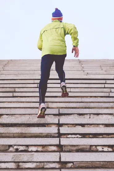 Ein Mann im Sportoutfit läuft eine Treppe hinauf – Pitta äußert sich in Motivation.