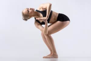 Eine Frau in Sportkleidung praktiziert die Yoga-Asana gedrehter Stuhl.